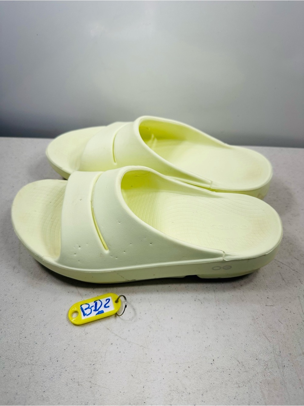 OOFOS OOahh recovery slides in a pale yellow hue size 9